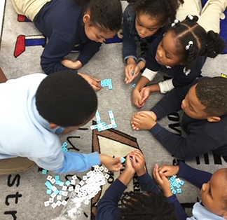 Group of students working together on the classroom floor